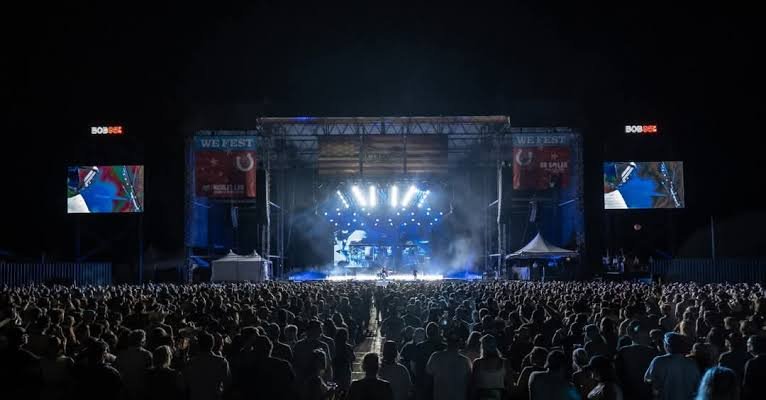Main stage setup at WEFest country music festival with performer entertaining crowd